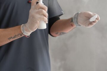 close up shot of a person spraying alcohol to the gauze