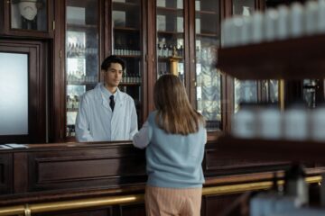 back view of person standing near the wooden counter