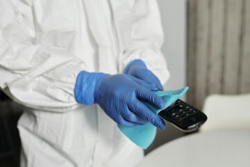a person disinfecting the remote control