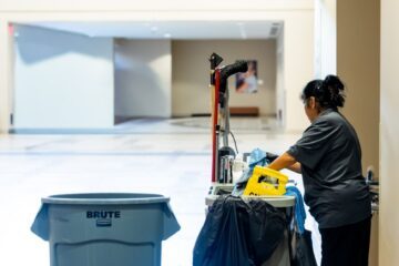 janitorial staff with cleaning equipment indoors