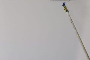 paint roller on white wall at home