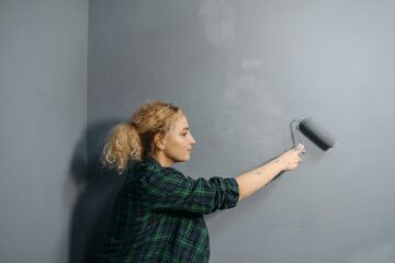 woman painting a wall using a