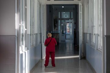 nurse walking in sunlit hospital corridor